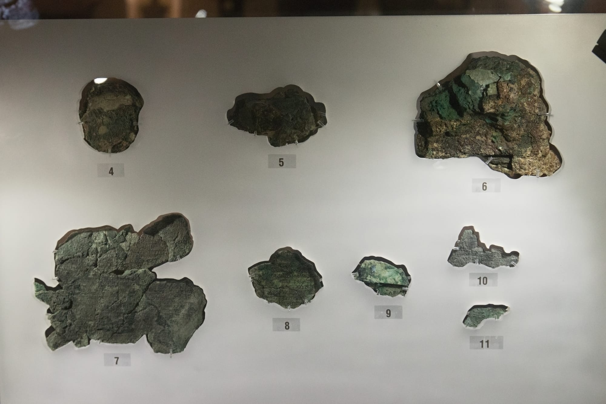 The Antikythera Mechanism, the corroded bronze gear assembly, photographed against a neutral backgro